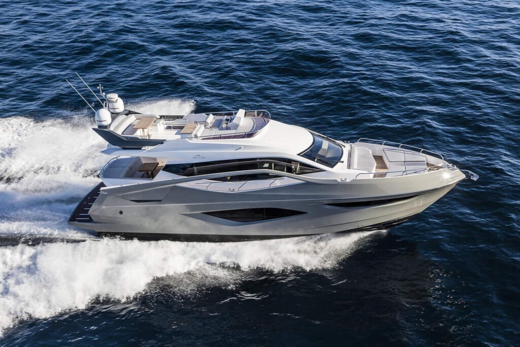 Miami Rent A Yacht A modern luxury yacht moves quickly across the open water, creating a white wake behind it under clear skies. Miami Yacht Rental
